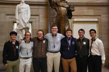 center of leadership group photo under statue