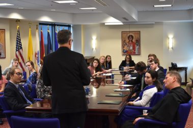 back of priest speaking at the center for leadership